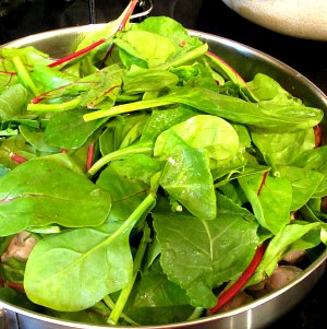 Adding baby greens to skillet