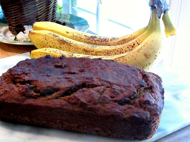 A loaf of fresh sugar free banana bread with ripe bananas. 