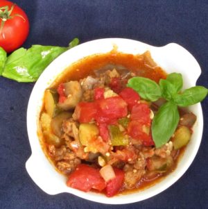 White dish of ratatouille with Italian sausage